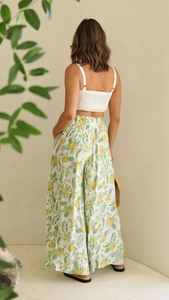 Detail of white knit crop top with open back and pineapple print wide leg trousers