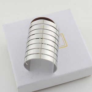 Detailed macro view of wide silver metallic hair tie cuff with hollow striped patterns