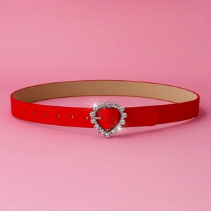 Detail of red leather belt featuring a heart-shaped buckle encrusted with shiny rhinestones