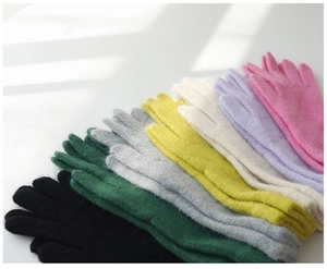 Detailed close-up of knitted rabbit fur gloves in various soft pastel color options