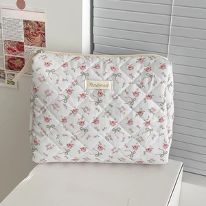 Quilted cotton floral makeup bag with pink ribbons and a gold zipper closure