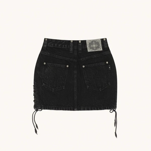 Détail du dos de la minijupe en jean noir avec broderie étoile et lacets latéraux à franges
