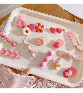 Detailed view of pink Y2K style children's hair clips with floral and heart shapes