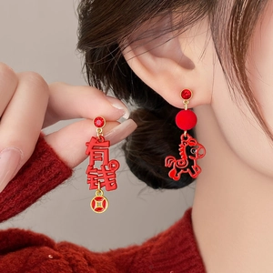 Detailed close-up of asymmetric red horse earrings with Chinese character charm and pompom