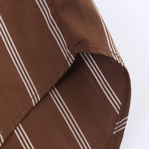 Detailed view of dark brown striped fabric texture and precision stitching on the shirt