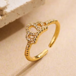 Macro shot of 18K gold plated crown ring with zircon stones on a warm textured background