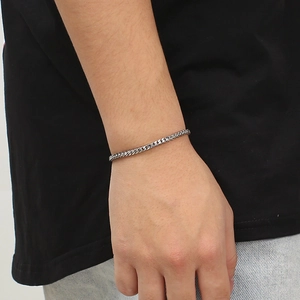 Close-up of minimalist stainless steel woven chain bracelet worn on a wrist