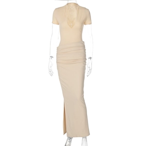 Detail view of cream-colored long dress featuring deep V-neck, side slit, and ruched texture
