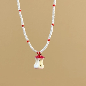 Handmade beaded necklace with red and white beads featuring a creative apple core pendant