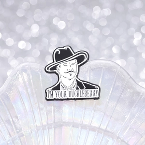 Cartoon metal enamel pin featuring a cowboy hat gentleman with I'm Your Huckleberry text