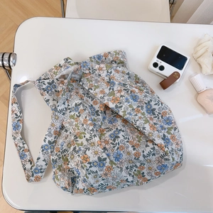 Flat lay of floral cotton tote bag with accessories showing delicate flower pattern