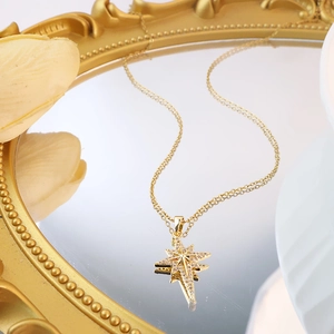 Goldene Nordstern-Halskette mit Zirkonia-Anhänger auf elegantem Spiegeltablett