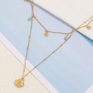 Double-layered gold necklace featuring fan shell pendants and light green beads