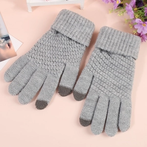 Close-up of thick knitted winter gloves with touchscreen fingertips on a soft background