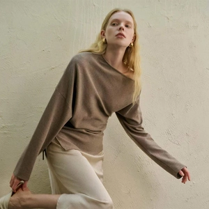 Elegant brown knit long sleeve off-shoulder sweater paired with beige skirt