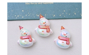 Close-up of three iridescent resin snowmen charms with red hats and star details