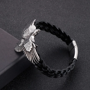 Detail of a braided leather bracelet featuring a silver eagle charm on a black gift box