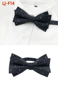 Close-up of black and white polka dot pre-tied bow tie on a white shirt collar
