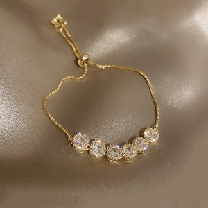 Adjustable gold plated bracelet with geometric zircon clusters on champagne silk