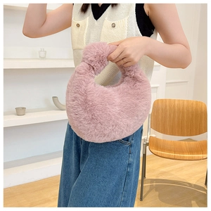 Detailed view of pink fuzzy crescent bag with a decorative knot handle design