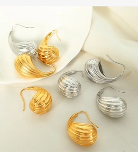 Dettaglio degli orecchini a goccia con strisce verticali in finitura oro e argento