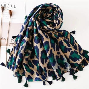 Blue and green leopard print scarf with tassels on a minimalist white background