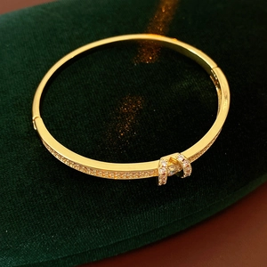 Detailed close-up of gold-plated bracelet with buckle design and inlaid zircon stones