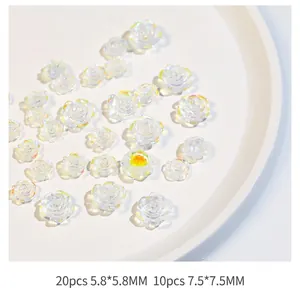 Macro detail of mixed size 3D pearl resin camellia nail art charms in white aurora finish