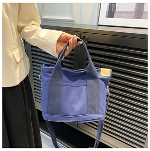 Borsa tote in tela blu con doppi manici e tracolla regolabile indossata da modella