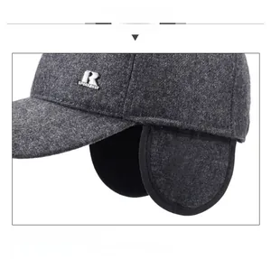 Detail view of winter baseball cap showing ear flaps and gray wool fabric texture