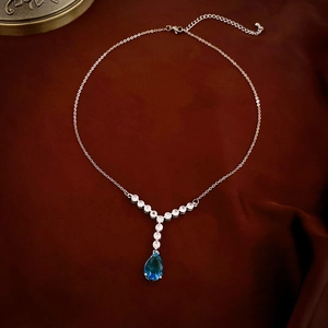 Détail du collier argenté avec pierre bleue en goutte d'eau et zircons étincelants