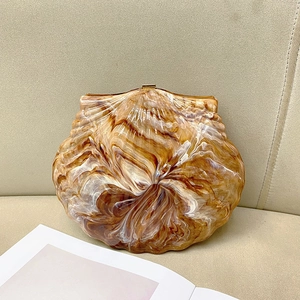 Elegant amber shell-shaped evening clutch bag with marble resin texture and gold clasp