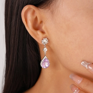 Close-up of elegant lavender teardrop drop earrings with sparkling diamond accents on model