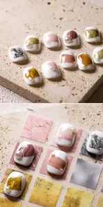 Detailed view of handmade marble-patterned press-on nails with pearls and gold foil