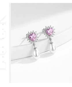 Detailed macro view of heart-shaped pink zircon earrings with elegant drop pearls