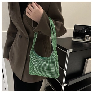 Macro shot of green rhinestone shoulder bag with crystal mesh texture and metal zipper