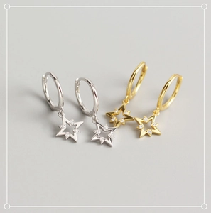 Détail de boucles d'oreilles étoile en argent et or avec zircons blancs brillants