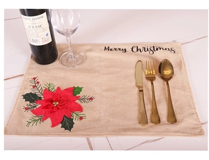 Detailed view of linen Christmas placemat with red flowers and golden cutlery set