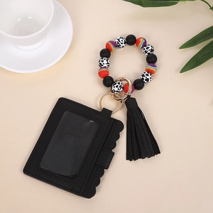 Detail of black wave edge PU leather card holder with cow print silicone beaded wristlet