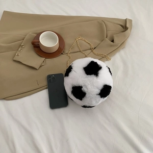 Detail of plush soccer-shaped crossbody bag with soft faux fur and gold chain strap