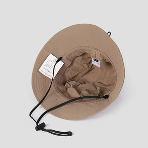 Detail view of khaki nylon sun hat featuring adjustable wind cord and interior sweatband