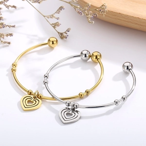 Three-layer heart charms open bracelets in gold and silver finish on white background
