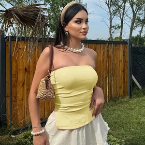 Détail du haut bustier jaune avec fente latérale et texture en maille douce