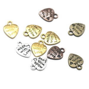 Detalle de colgantes de metal en forma de corazón con grabado 'made with love' DIY