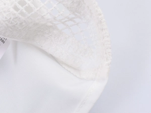 Macro shot of white embroidered floral lace texture and lining of this shirt