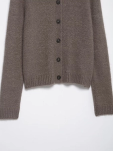 Detailed close-up of dark brown knit cardigan with faux fur texture and dark round buttons