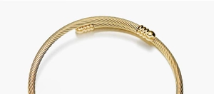 Detailed close-up of golden cable twist bangle featuring smooth polished end caps