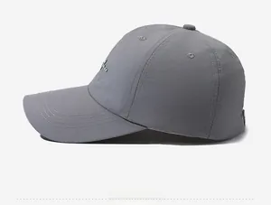 Side view of gray quick-dry baseball cap featuring green embroidered text and stitched brim