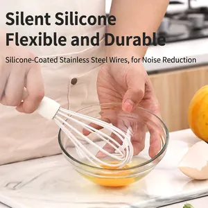 White food grade silicone whisk with stainless steel wires on marble kitchen counter