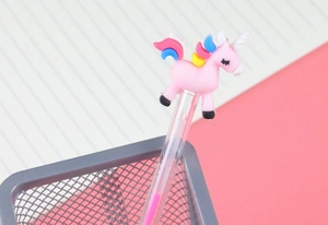 Close-up of cute pink unicorn pen topper with colorful mane on transparent pen barrel